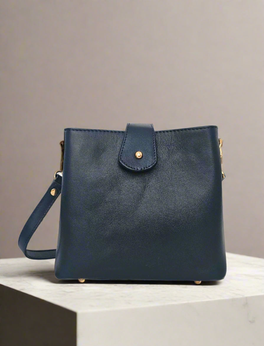 Navy blue leather handbag with gold accents on a white background