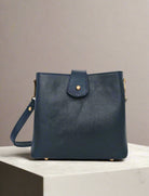 Navy blue leather handbag with gold accents on a white background