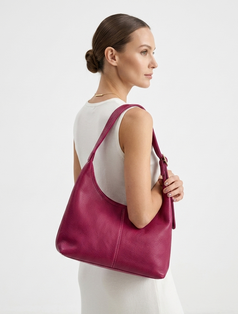 women holding a leather shoulder bag in magenta color from MBH Leather